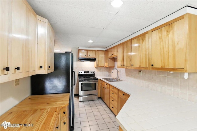 933 W 20th Ave, Anchorage, AK 99503 - kitchen with freestanding refrigerator, stainless steel electric stove, decorative backsplash, light brown cabinetry, and light tile patterned floors