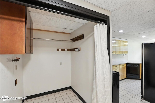 933 W 20th Ave, Anchorage, AK 99503 - kitchen with a paneled ceiling, black appliances, light tile patterned floors, and light countertops