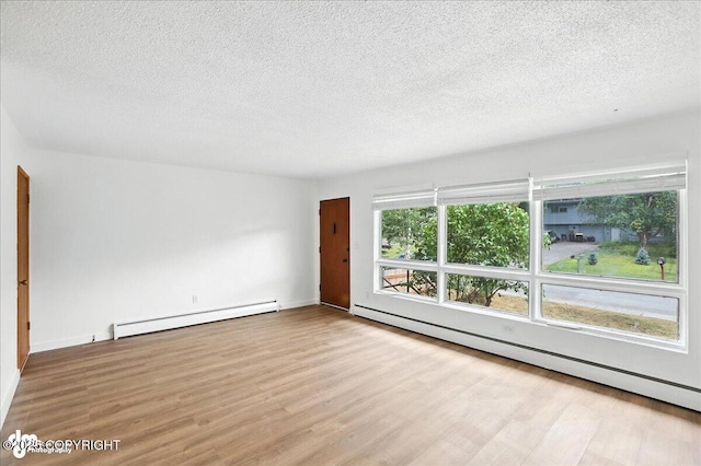 933 W 20th Ave, Anchorage, AK 99503 - unfurnished room with a baseboard radiator, a textured ceiling, and wood finished floors