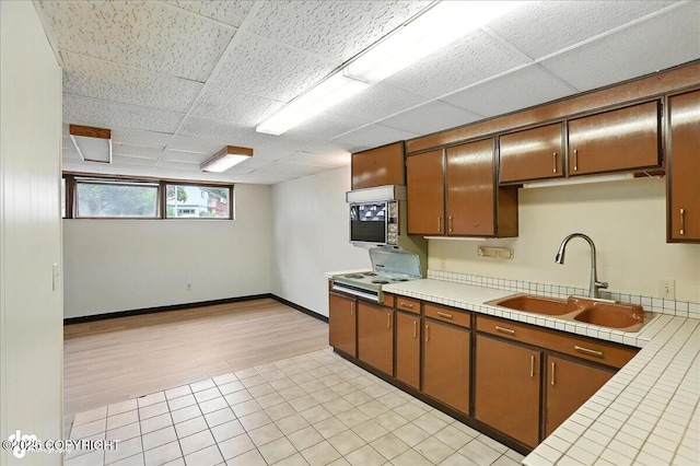 933 W 20th Ave, Anchorage, AK 99503 - kitchen with tile counters, a paneled ceiling, and light tile patterned floors