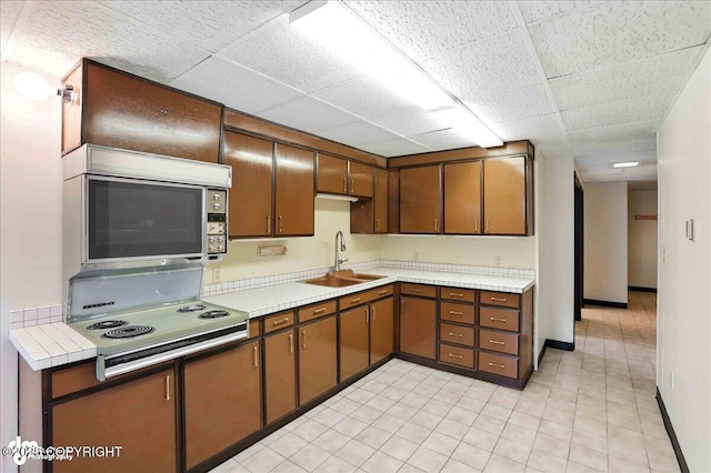 933 W 20th Ave, Anchorage, AK 99503 - kitchen with a paneled ceiling, stainless steel microwave, electric stove, and light tile patterned floors