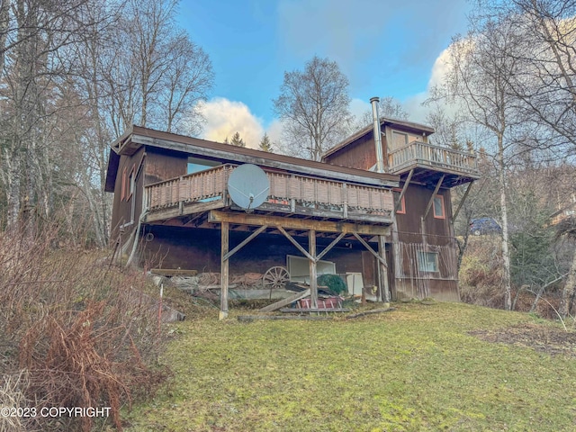 rear view of property with a yard and a deck