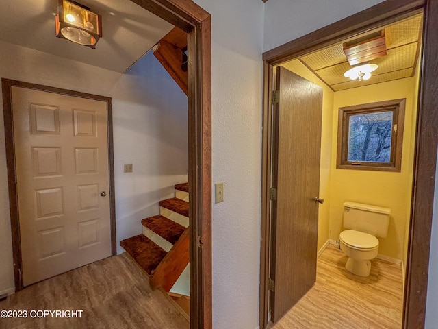 corridor with wood finished floors and stairs