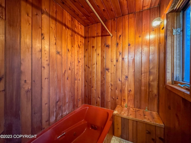 bathroom with a bath, wood ceiling, wood walls, and a sauna / steam room