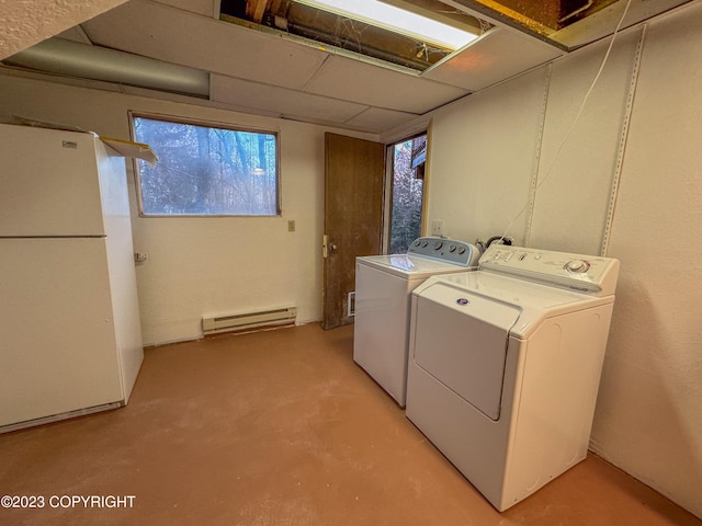 laundry area with a baseboard heating unit, independent washer and dryer, and healthy amount of natural light