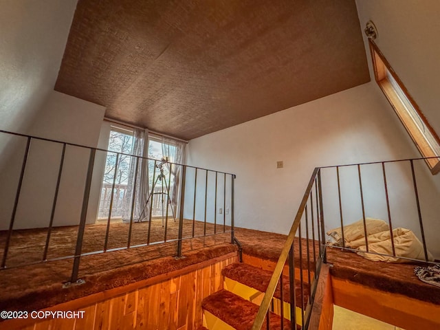 stairway with wood finished floors and a textured ceiling