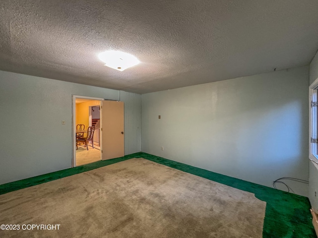 empty room featuring carpet flooring and a textured ceiling