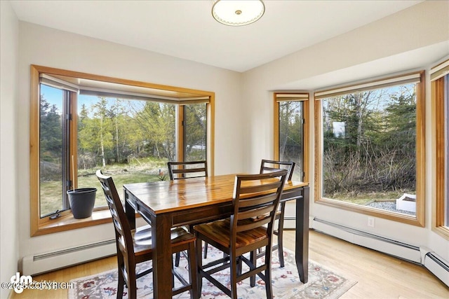 dining space featuring light wood-style floors and baseboard heating