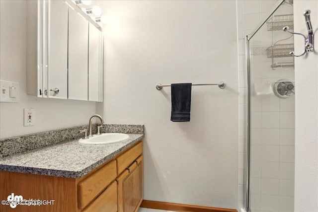 full bath with a tile shower and vanity