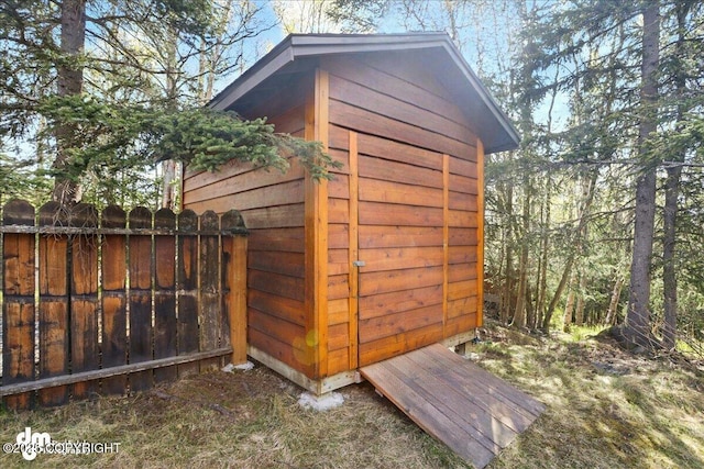 view of shed featuring fence