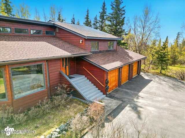 view of front of house with roof with shingles and a detached garage