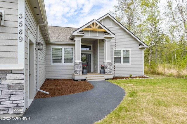 3589 N Magnolia Cir, Wasilla, AK 99654 - property entrance featuring a yard, roof with shingles, and stone siding
