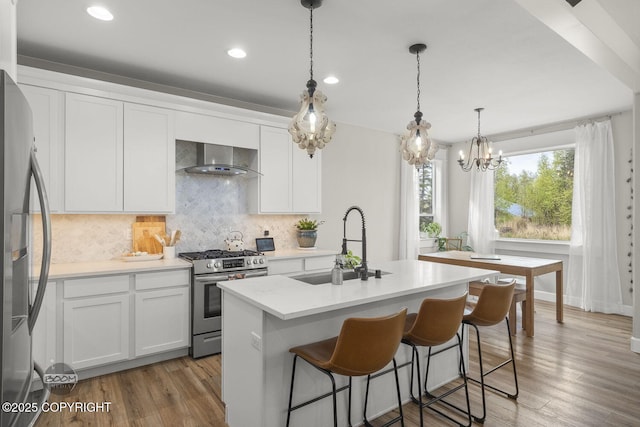 3589 N Magnolia Cir, Wasilla, AK 99654 - kitchen with stainless steel appliances, wall chimney exhaust hood, a sink, backsplash, and white cabinets
