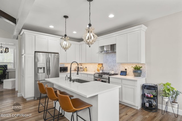 3589 N Magnolia Cir, Wasilla, AK 99654 - kitchen with appliances with stainless steel finishes, wall chimney range hood, a sink, a chandelier, and decorative backsplash