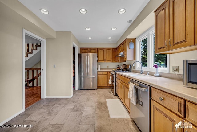6010 Staedem Dr, Anchorage, AK 99504 - kitchen with appliances with stainless steel finishes, under cabinet range hood, light countertops, a sink, and baseboards