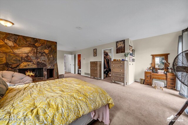 6010 Staedem Dr, Anchorage, AK 99504 - bedroom featuring carpet floors, a spacious closet, a closet, and a stone fireplace