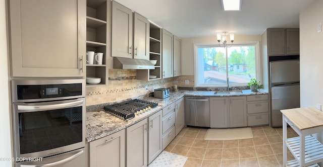 741 W 20th Ave, Anchorage, AK 99503 - kitchen featuring stainless steel appliances, open shelves, light stone countertops, tasteful backsplash, and under cabinet range hood