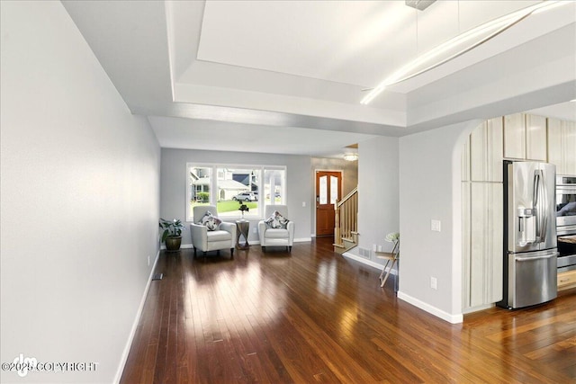 3833 Eastwind Dr, Anchorage, AK 99516 - living room featuring a tray ceiling, baseboards, and dark wood finished floors
