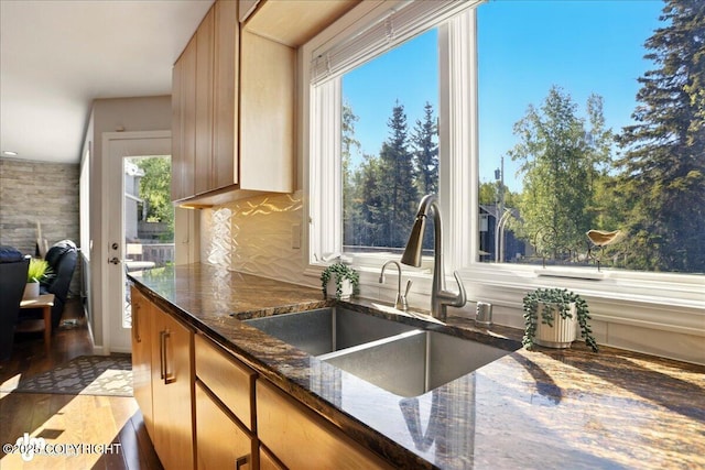 3833 Eastwind Dr, Anchorage, AK 99516 - kitchen with a sink, dark stone counters, and wood finished floors