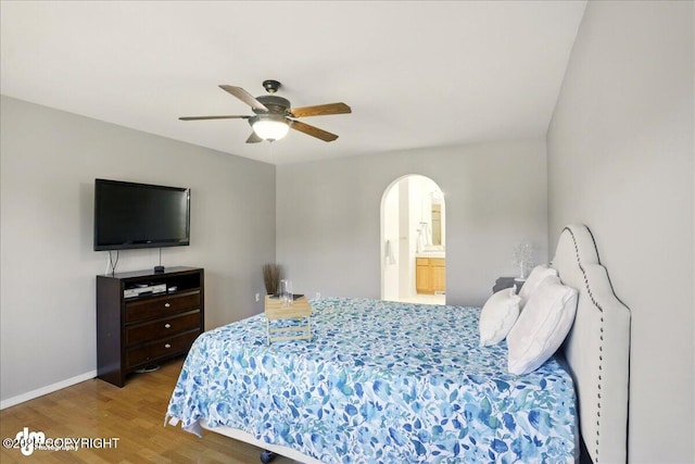 3833 Eastwind Dr, Anchorage, AK 99516 - bedroom with arched walkways, wood finished floors, baseboards, a ceiling fan, and ensuite bathroom