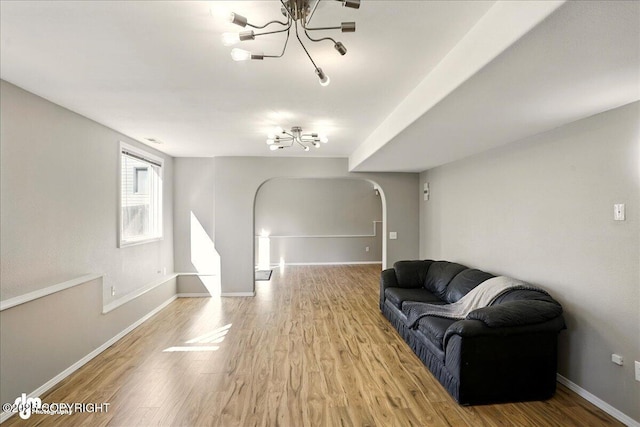 3833 Eastwind Dr, Anchorage, AK 99516 - living area with arched walkways, wood finished floors, a chandelier, and baseboards
