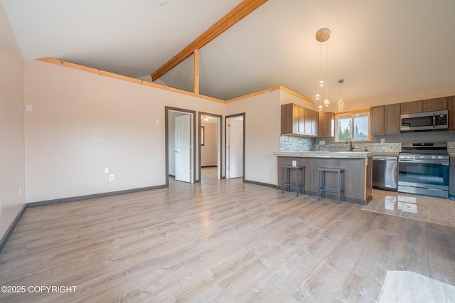 33533 Alder St, Anchor Point, AK 99556 - kitchen featuring appliances with stainless steel finishes, high vaulted ceiling, baseboards, light countertops, and light wood-style floors