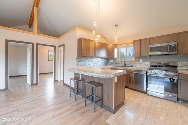 33533 Alder St, Anchor Point, AK 99556 - kitchen with appliances with stainless steel finishes, a kitchen bar, light countertops, a peninsula, and plenty of natural light