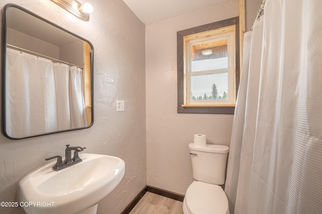 33533 Alder St, Anchor Point, AK 99556 - full bathroom featuring a sink, wood finished floors, toilet, baseboards, and a textured wall