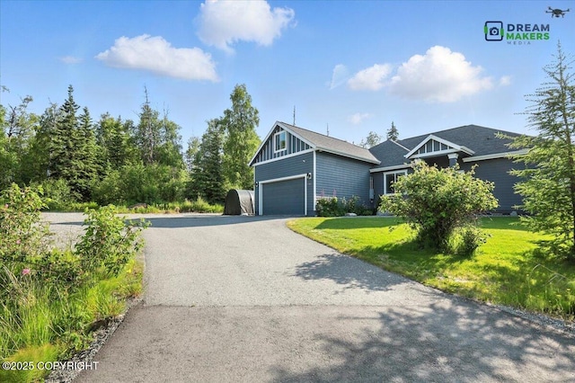 7782 W Arlie Rd, Wasilla, AK 99623 - view of front of house featuring a front lawn, driveway, an attached garage, and board and batten siding