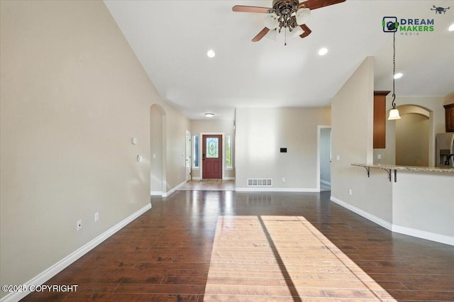 7782 W Arlie Rd, Wasilla, AK 99623 - unfurnished living room with arched walkways, ceiling fan, dark wood-type flooring, and recessed lighting