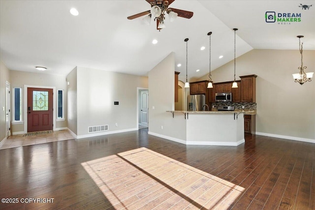 7782 W Arlie Rd, Wasilla, AK 99623 - kitchen with appliances with stainless steel finishes, a peninsula, a breakfast bar, a ceiling fan, and decorative light fixtures