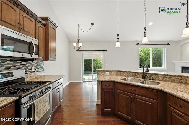 7782 W Arlie Rd, Wasilla, AK 99623 - kitchen featuring stainless steel appliances, healthy amount of natural light, dark wood-style floors, and light stone counters