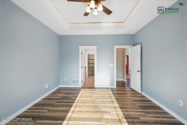 7782 W Arlie Rd, Wasilla, AK 99623 - unfurnished bedroom featuring a tray ceiling, dark wood-style floors, ornamental molding, and a ceiling fan