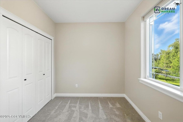 7782 W Arlie Rd, Wasilla, AK 99623 - unfurnished bedroom featuring light colored carpet, multiple windows, and a closet