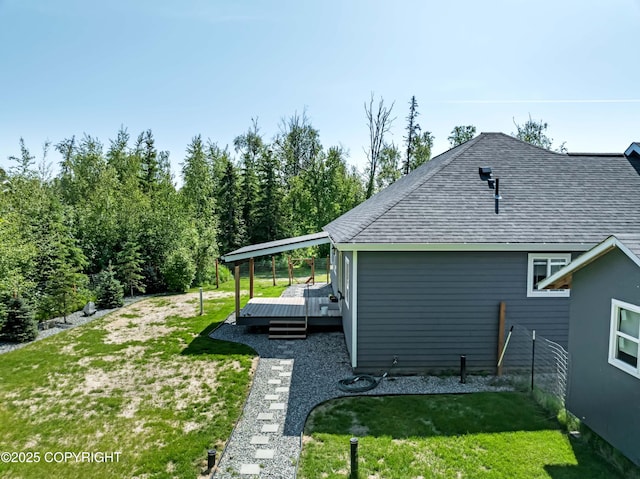 7782 W Arlie Rd, Wasilla, AK 99623 - view of side of property featuring a deck, a lawn, and roof with shingles
