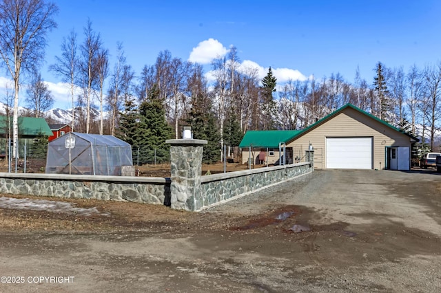 exterior space with an exterior structure, an attached garage, an outdoor structure, and driveway