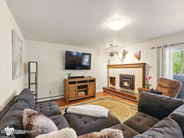 living room with wood finished floors, baseboard heating, and a fireplace