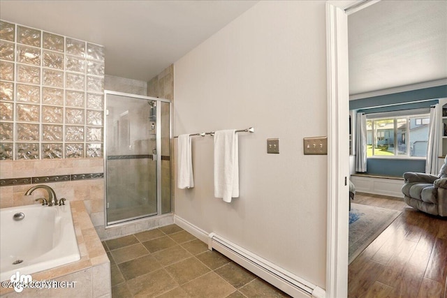bathroom with a baseboard radiator, a stall shower, a garden tub, and baseboards