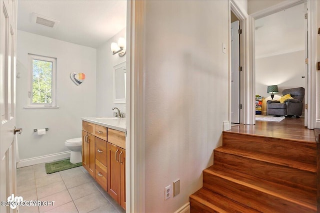 bathroom with vanity, toilet, tile patterned floors, and baseboards