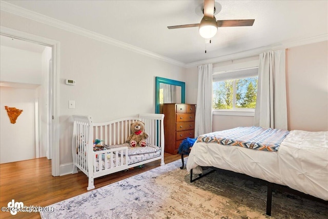 bedroom featuring wood finished floors, crown molding, and a ceiling fan