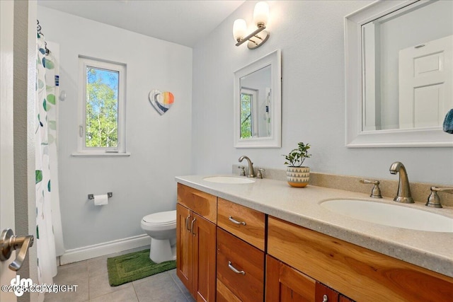 full bath with toilet, double vanity, tile patterned floors, and baseboards