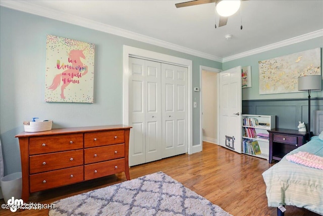 bedroom featuring ornamental molding, wood finished floors, a closet, and a ceiling fan