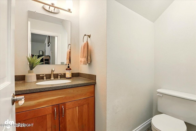 half bathroom featuring toilet and vanity