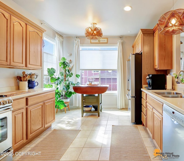 kitchen featuring dishwasher, stainless steel refrigerator with ice dispenser, a sink, range with electric stovetop, and light tile patterned floors