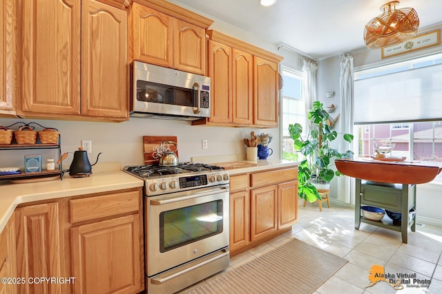 kitchen with appliances with stainless steel finishes, light countertops, light tile patterned flooring, and recessed lighting