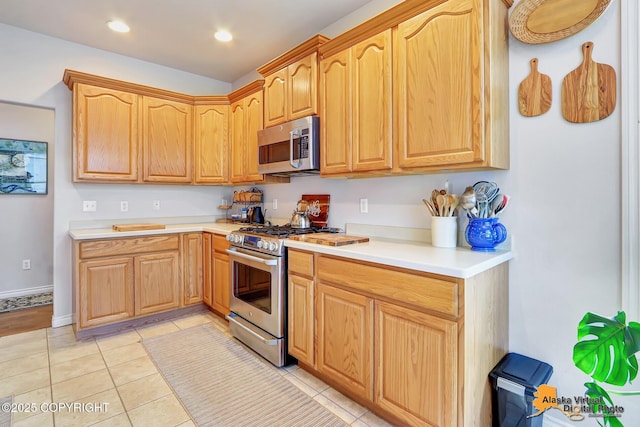 kitchen featuring stainless steel appliances, light countertops, light tile patterned flooring, recessed lighting, and light brown cabinets