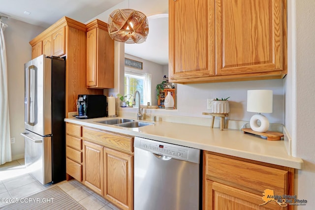 kitchen with appliances with stainless steel finishes, a sink, light tile patterned flooring, and light countertops