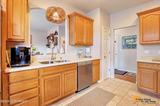 kitchen with dishwasher, a sink, light tile patterned floors, and light countertops