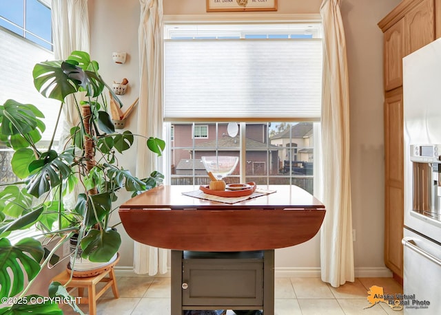 dining area featuring light tile patterned flooring and baseboards
