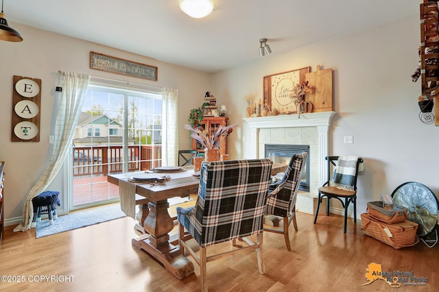 dining room with wood finished floors and a fireplace